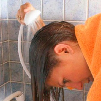Mujer usando el grifo de ducha especial